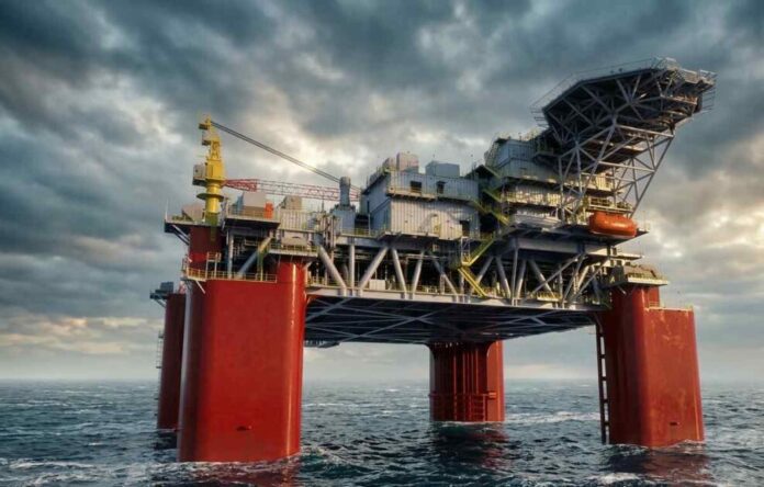 A massive offshore oil drilling platform floating in deep ocean waters under a cloudy sky.