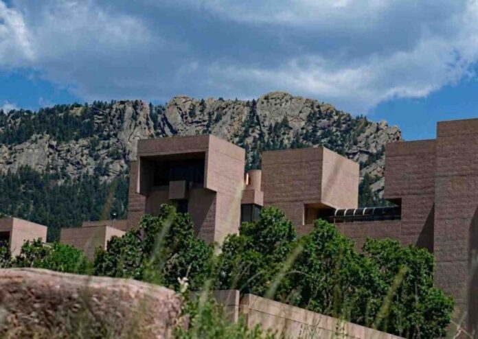 A large architectural scientific laboratory building situated against a mountainous backdrop in Colorado.